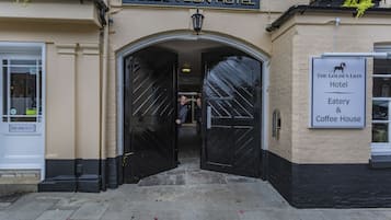 De ingang van Hotel Golden Lion, met een bord dat aangeeft dat er een eetgelegenheid en koffiehuis is.