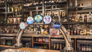 A bar with multiple taps, including brands like Tennent's, Somersby, and Guinness.