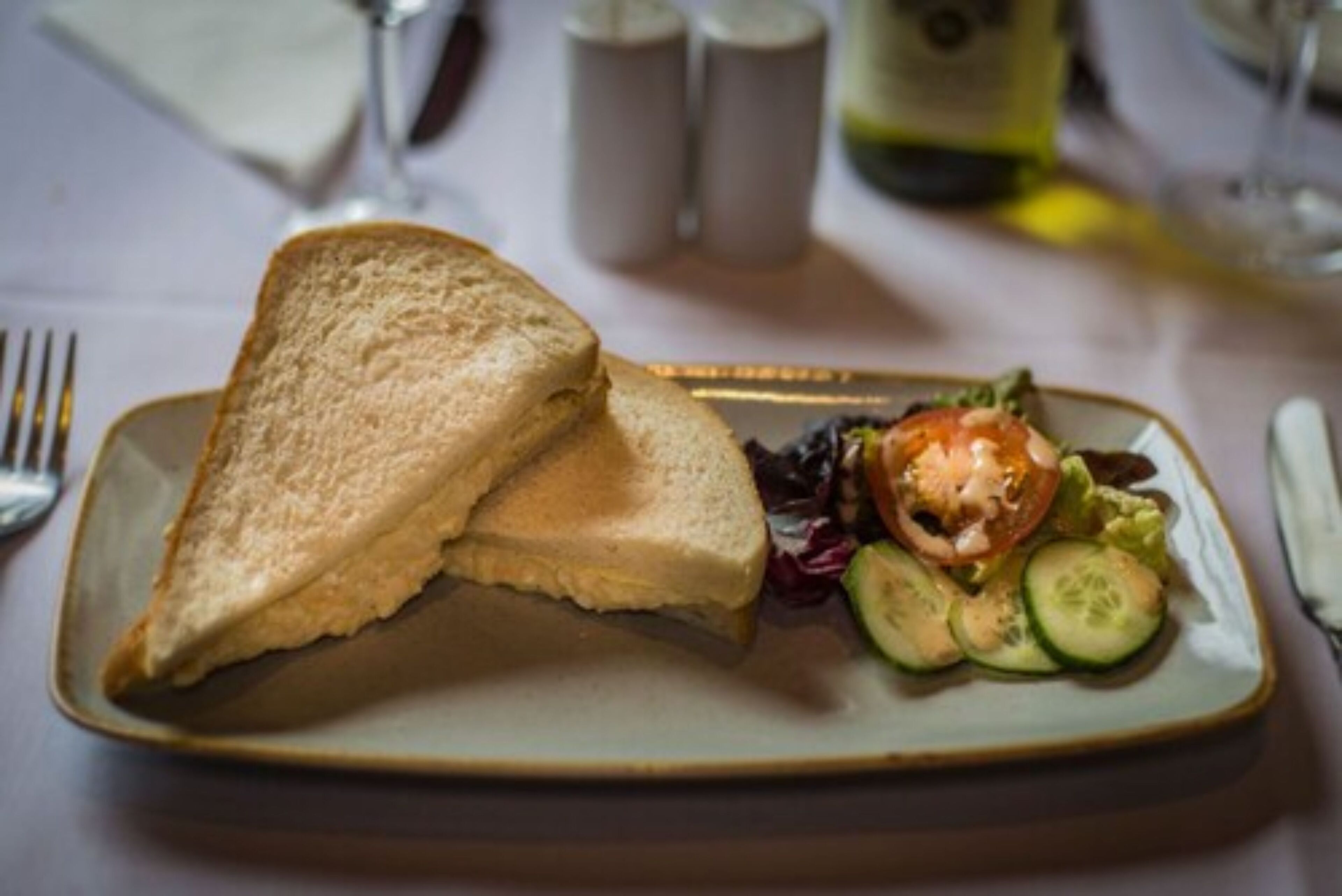 Un plato con un sándwich y una ensalada.