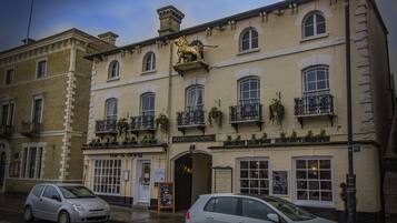 A building with a lion statue, multiple windows, and a sign for the Golden Lion Hotel.