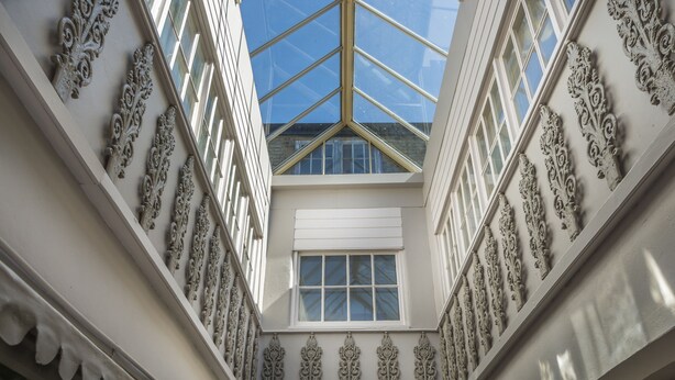 A high-ceilinged atrium with ornate white railings and a skylight. - The Golden Lion Hotel, St Ives, Cambridgeshire (St Ives)