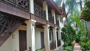 Un edificio tradicional con galería cubierta, columnas y barandilla de madera.