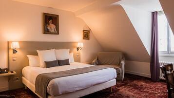 A hotel room with a large bed, two bedside lamps, a chair, a window with curtains, and a painting on the wall.