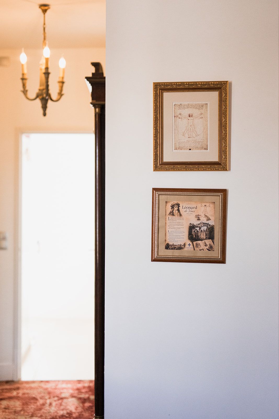 A wall with two framed items, one with text and another with a portrait and text.