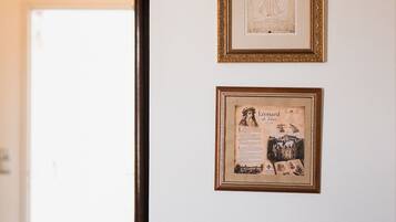 A wall with two framed items, one with text and another with a portrait and text.