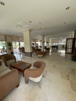 A spacious lobby with modern furniture, a pool table, and large windows allowing natural light.