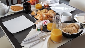 A breakfast table with croissants, fruit, juice, and a teapot. - Be Loft B&B Pool & Spa (Avignon)