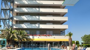 A hotel with a swimming pool, a lifeguard tower, and a clear blue sky. - Hotel Cormoran (Cattolica)