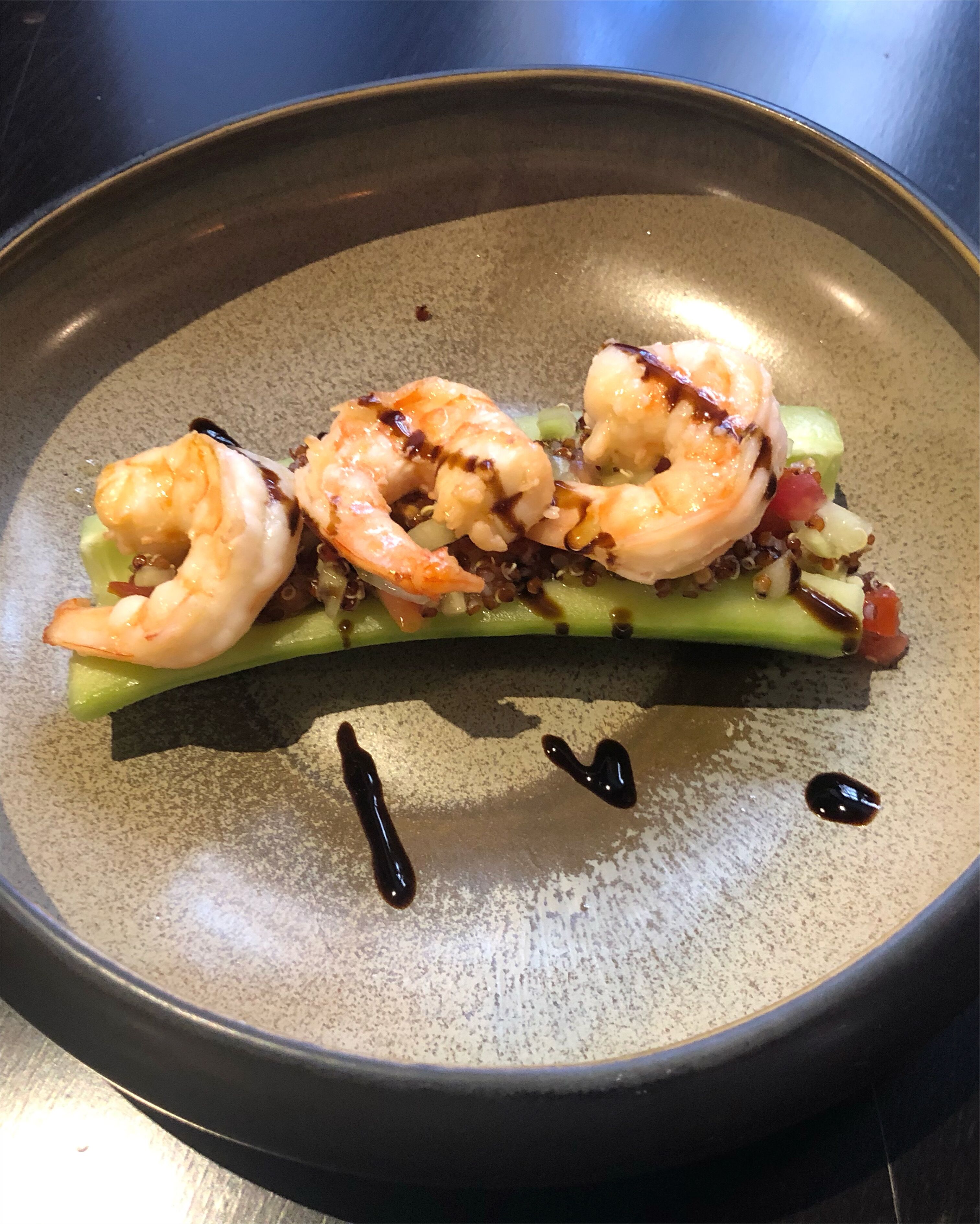 Un plat amb gambes i verdures en una paella.
