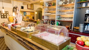 A buffet area with various food items and a glassware display. - Au Cheval Blanc Hôtel et Restaurant (Ribeauvillé)