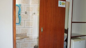 A bathroom with a shower, toilet, and sink. - Rota de Geribá Suítes (Búzios)