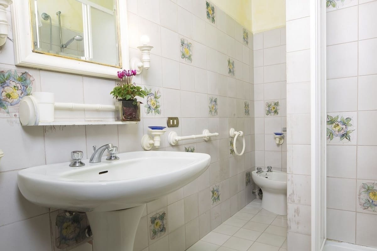 A bathroom with a sink, mirror, and toilet.