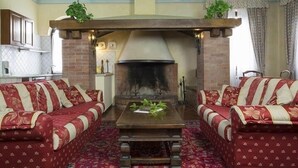 A cozy living room with a fireplace, two sofas, and a coffee table. - Bosco Lazzeroni Residence (Montaione)