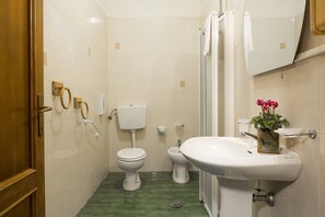 A bathroom with a toilet, bidet, and sink.