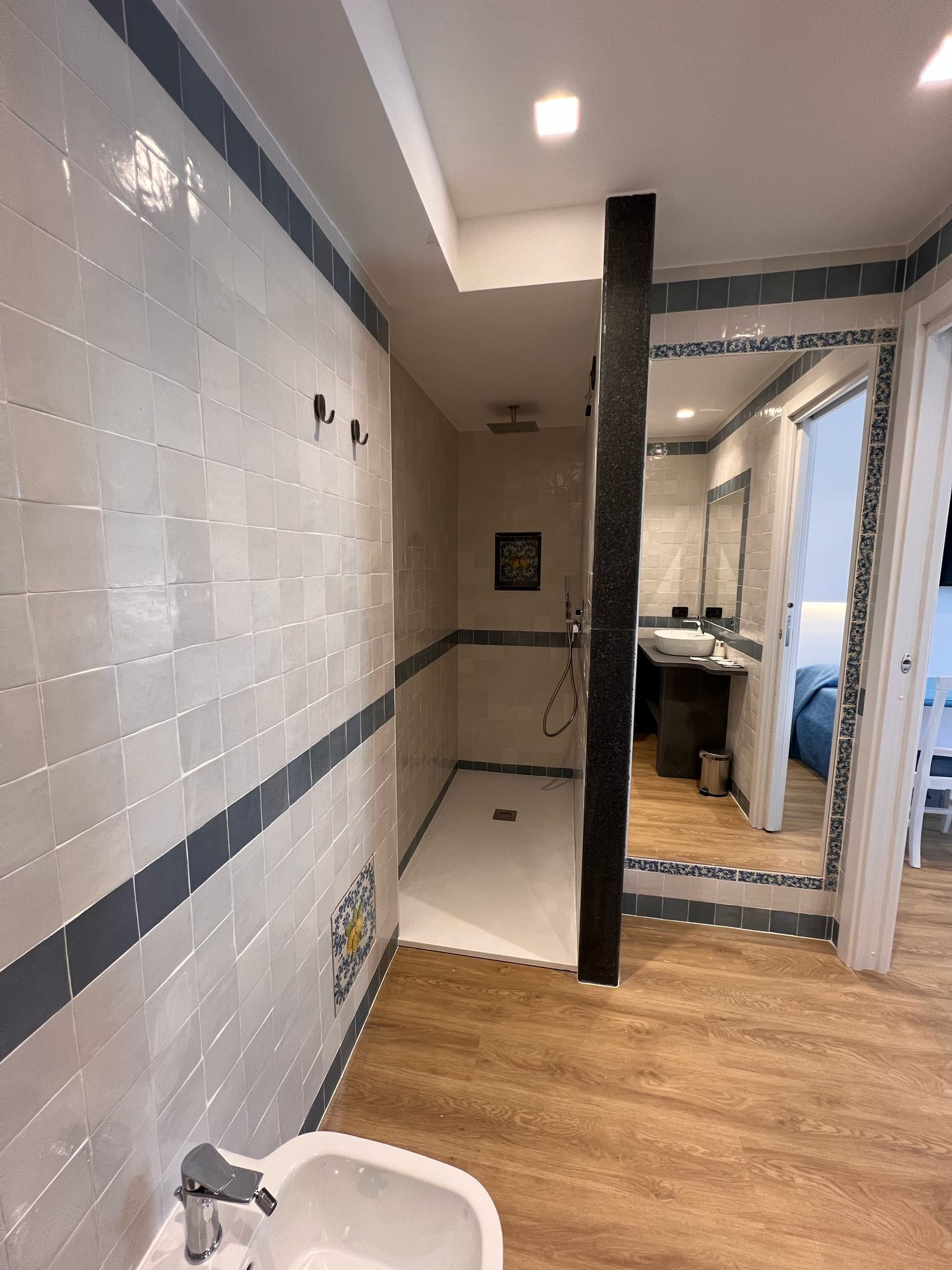 A modern bathroom with a shower, a sink, and a mirror.