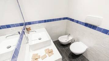 Ein Badezimmer mit Waschbecken, Bidet und Toilette.