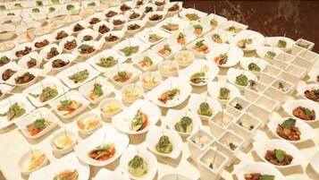 Un buffet con diversi piatti disposti in ciotole bianche.