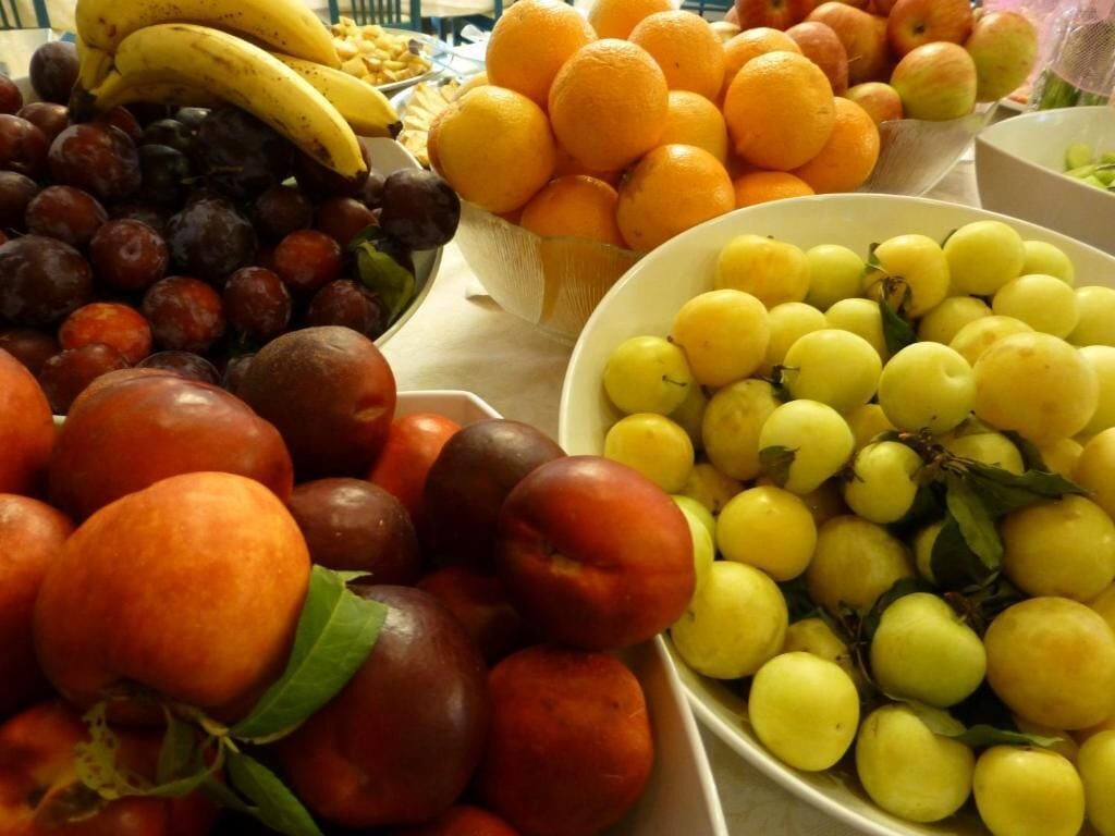 A table with various fruits including apples, oranges, and grapes.