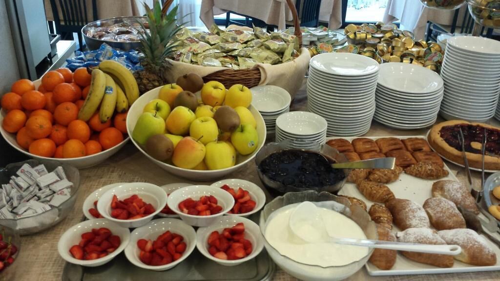 A buffet with various fruits, pastries, and desserts.