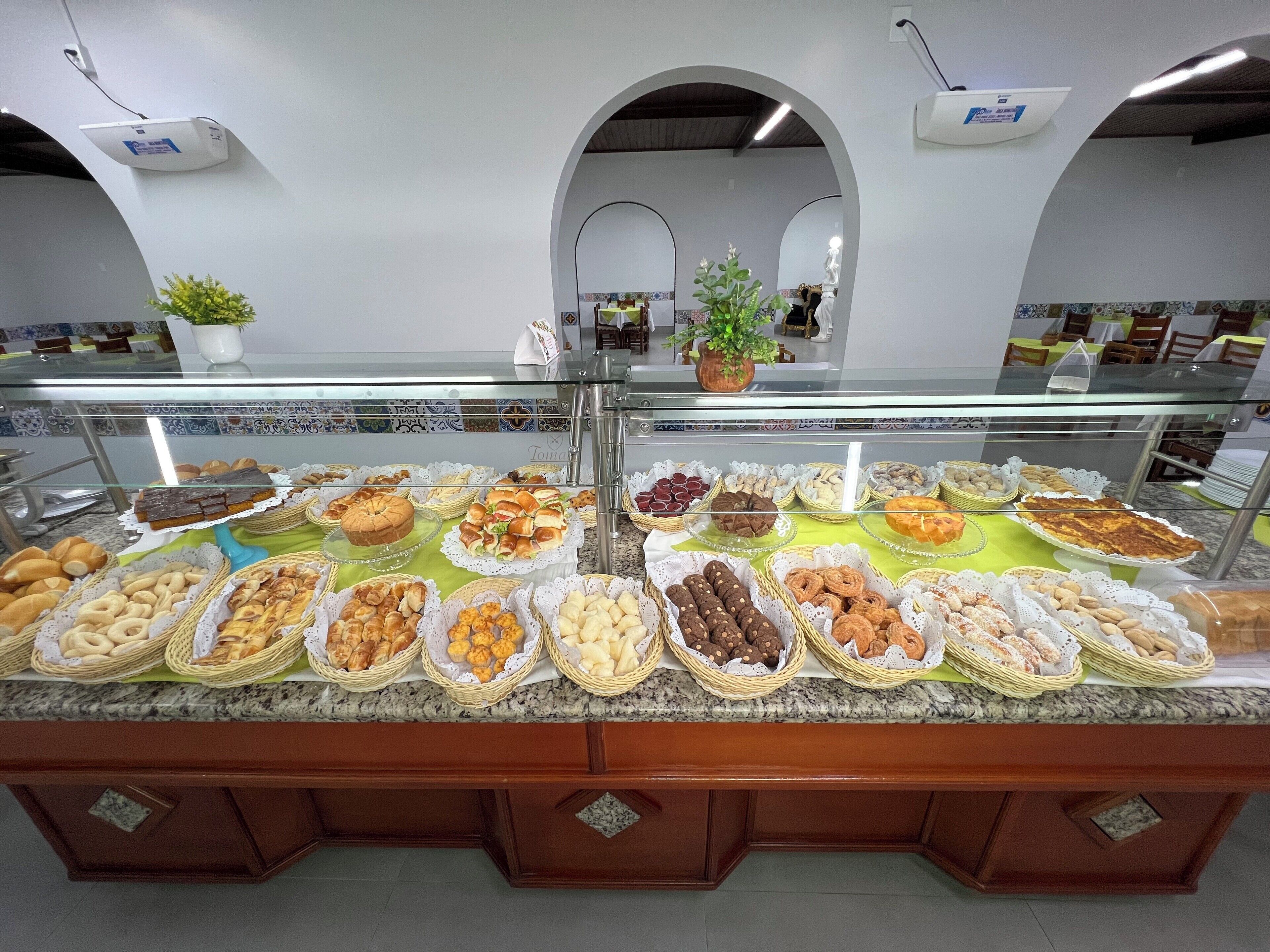 Een buffet met diverse gebakjes en patisserie, gepresenteerd in rieten manden.