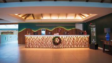 Una reception con uno sfondo decorativo, uno schermo digitale e un cartello per un ristorante.