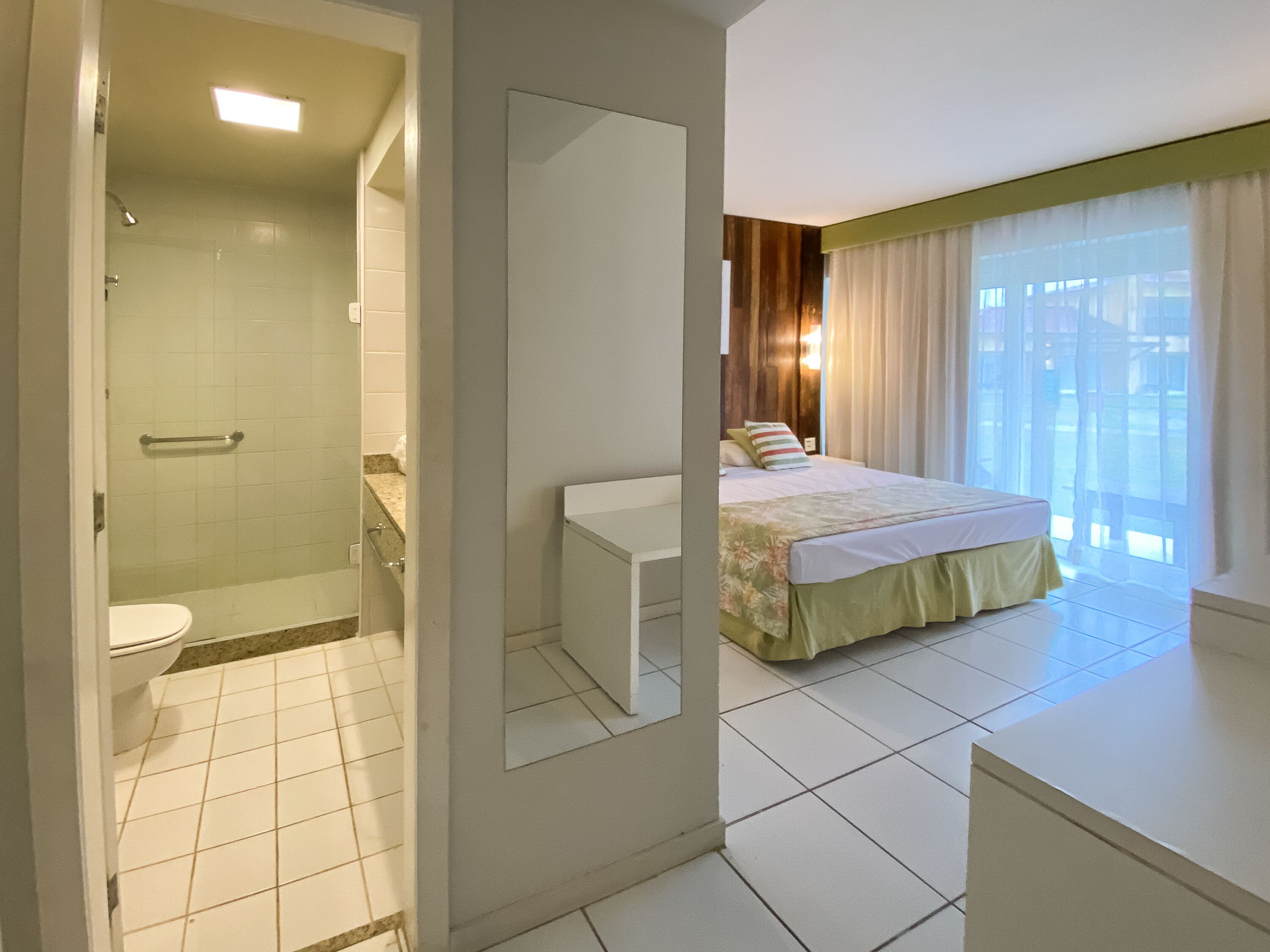 A hotel bathroom with a shower, toilet, and sink.