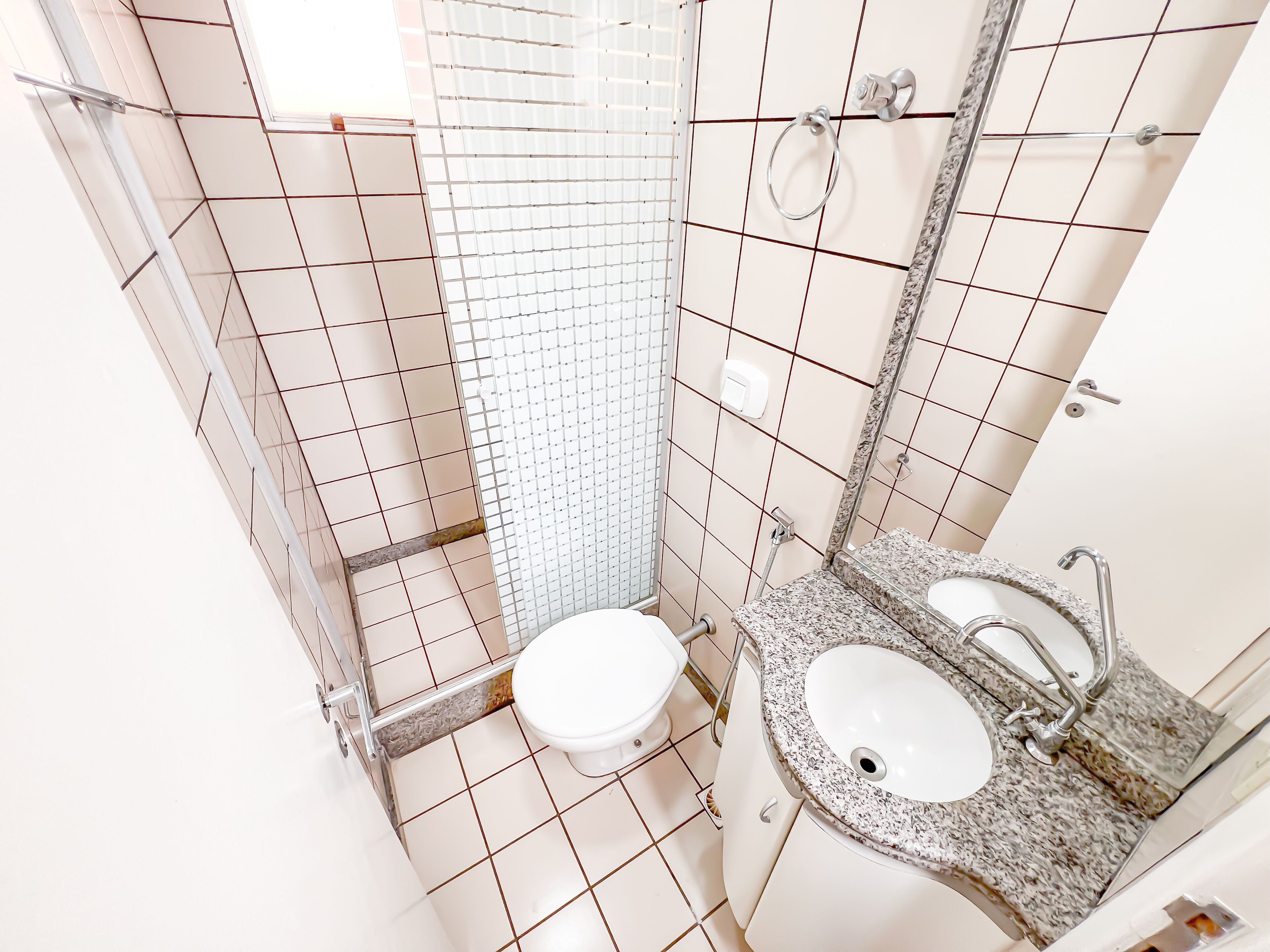 A bathroom with a toilet, sink, and shower.