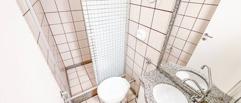 A bathroom with a toilet, sink, and shower.