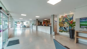 A spacious lobby with a reception desk, seating area, and a large mural on the wall. - DiRoma Resort - Direto com o Grupo DiRoma - acesso ao Acqua Park com café da manhã (Caldas Novas)