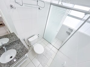 A modern bathroom with a double sink, toilet, and glass shower enclosure. - DiRoma Lacqua II - Direto com o Grupo DiRoma - acesso ao Acqua Park com café da manhã (Caldas Novas)