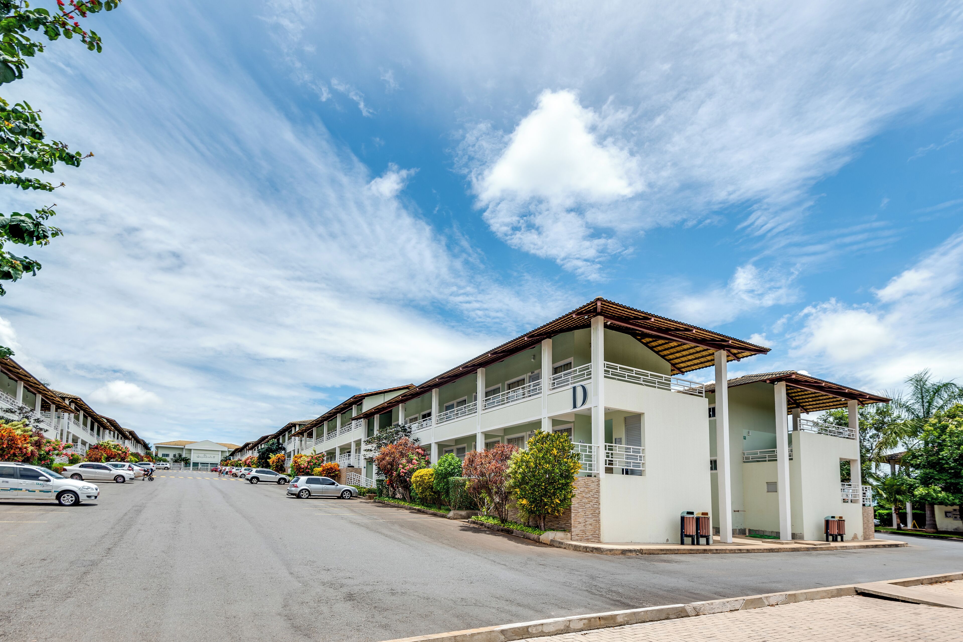 A hotel with a central courtyard, multiple floors, and a covered outdoor seating area.