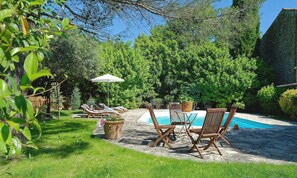 Una piscina al aire libre, sombrillas, tumbonas
