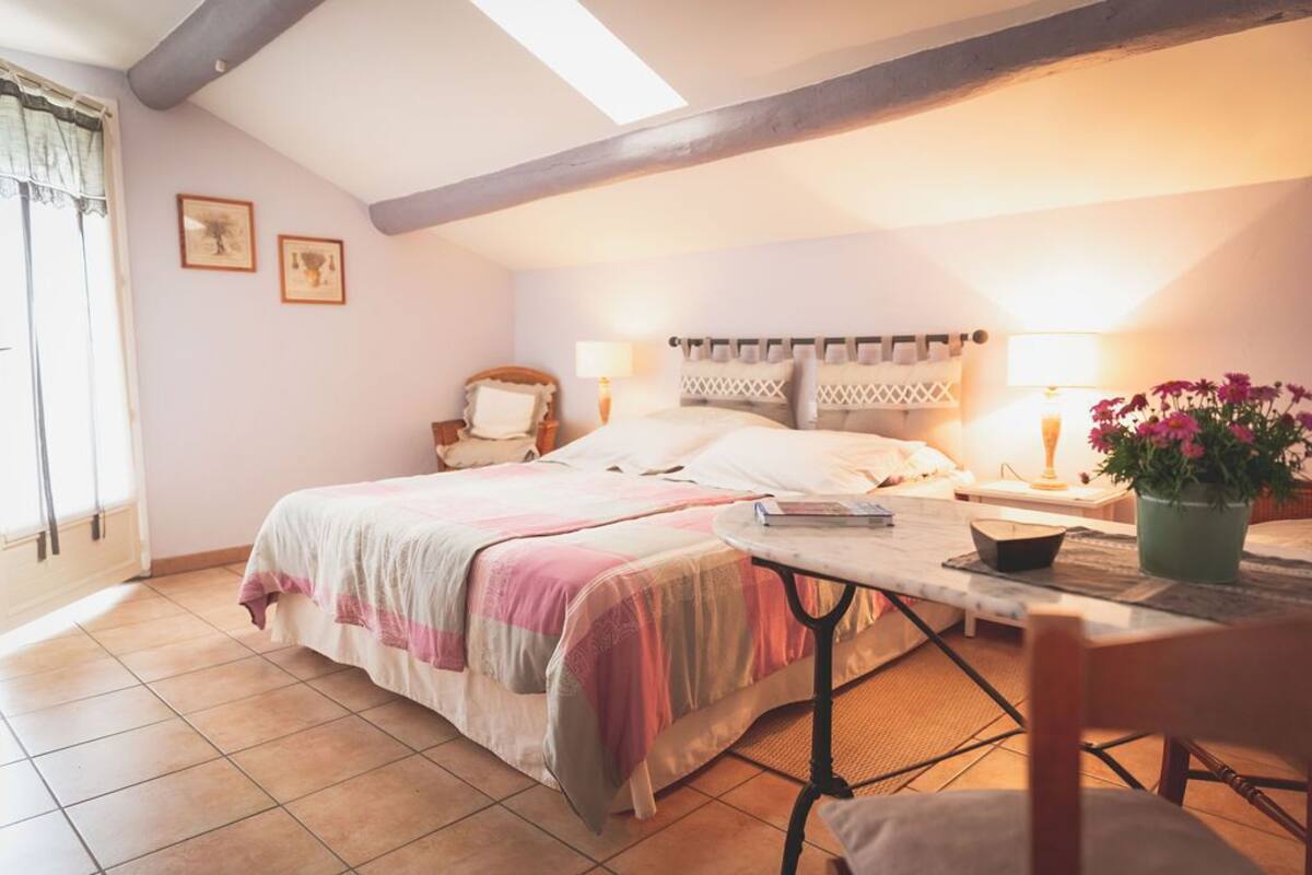 Une chambre confortable avec un lit, des lampes de chevet, une petite table et une chaise.