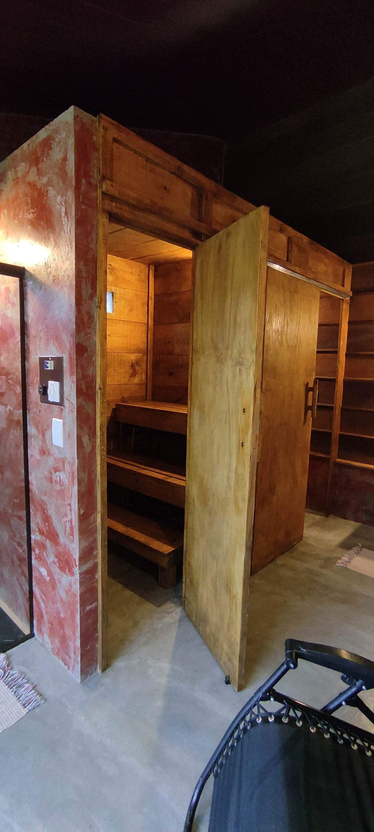 Une pièce en bois avec un banc intégré et une porte dotée d’un panneau de commande.