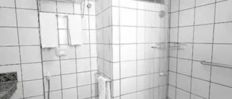 Un baño moderno con inodoro, cabina de ducha y suelo de baldosas.