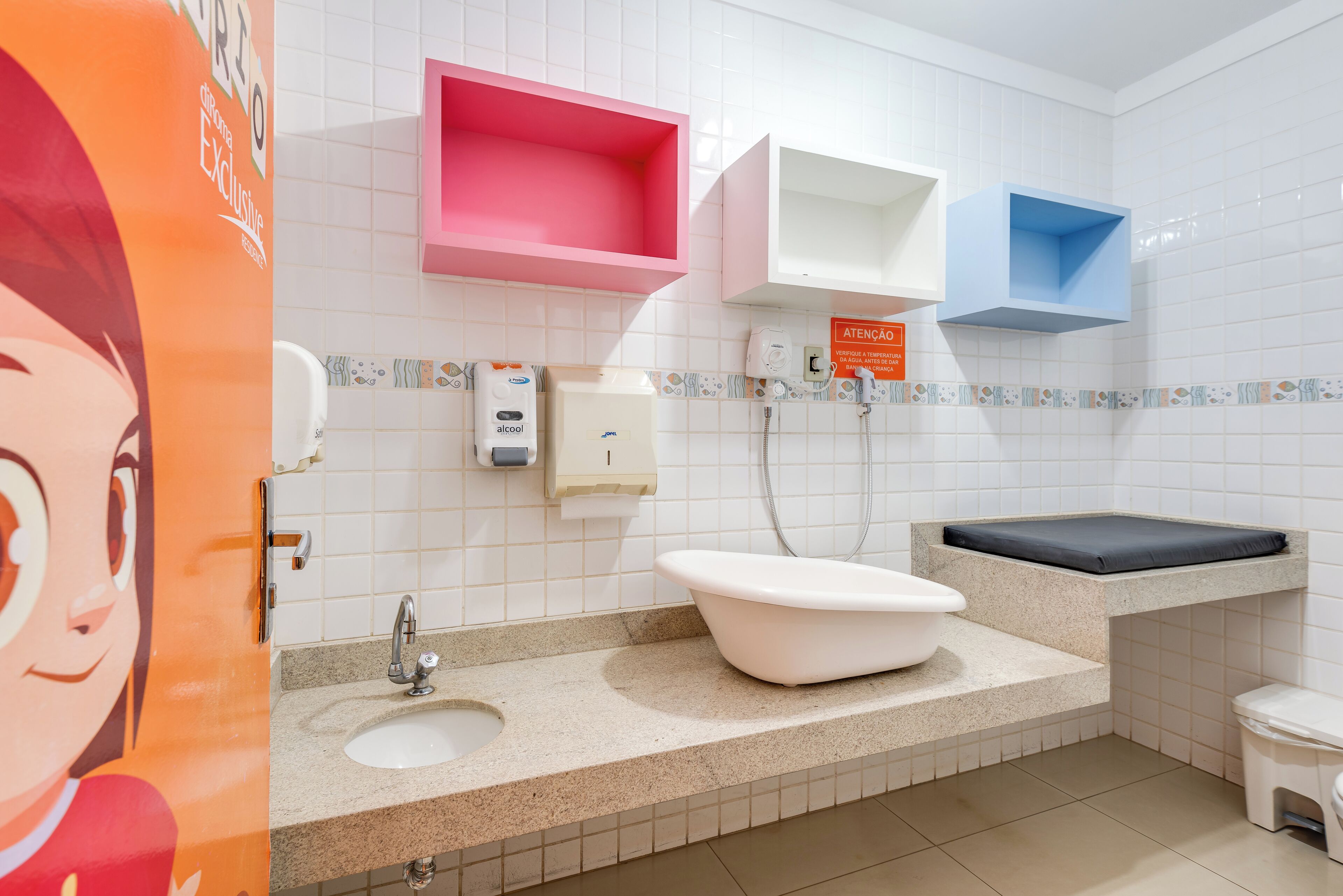 A bathroom with a sink, toilet, and a shelf with a sign.