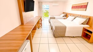 A hotel room with a wooden desk, two single beds, a large bed, a TV, and a balcony with a view. - DiRoma Exclusive - Direto com o Grupo DiRoma - acesso ao Acqua Park com café da manhã (Caldas Novas)