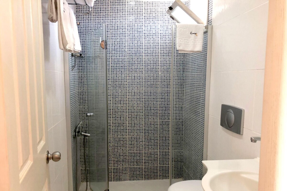 A small bathroom with a shower, toilet, and sink.