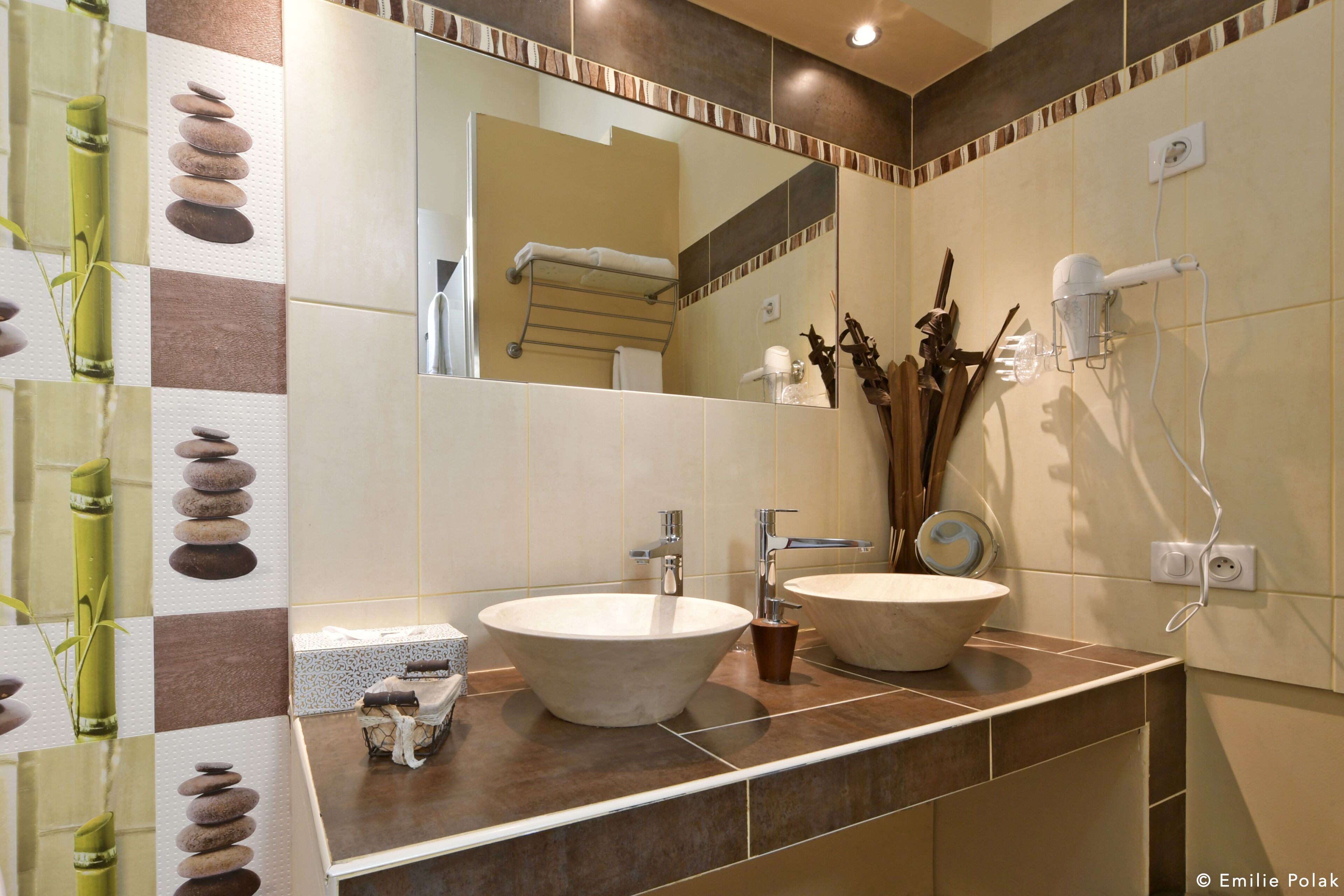 A bathroom with two sinks, a mirror, and a towel rack.