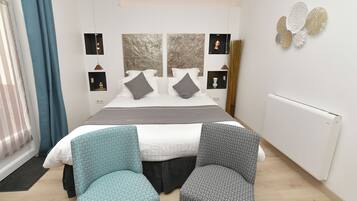 A modern bedroom with a large bed, two bedside tables, and a window with curtains.