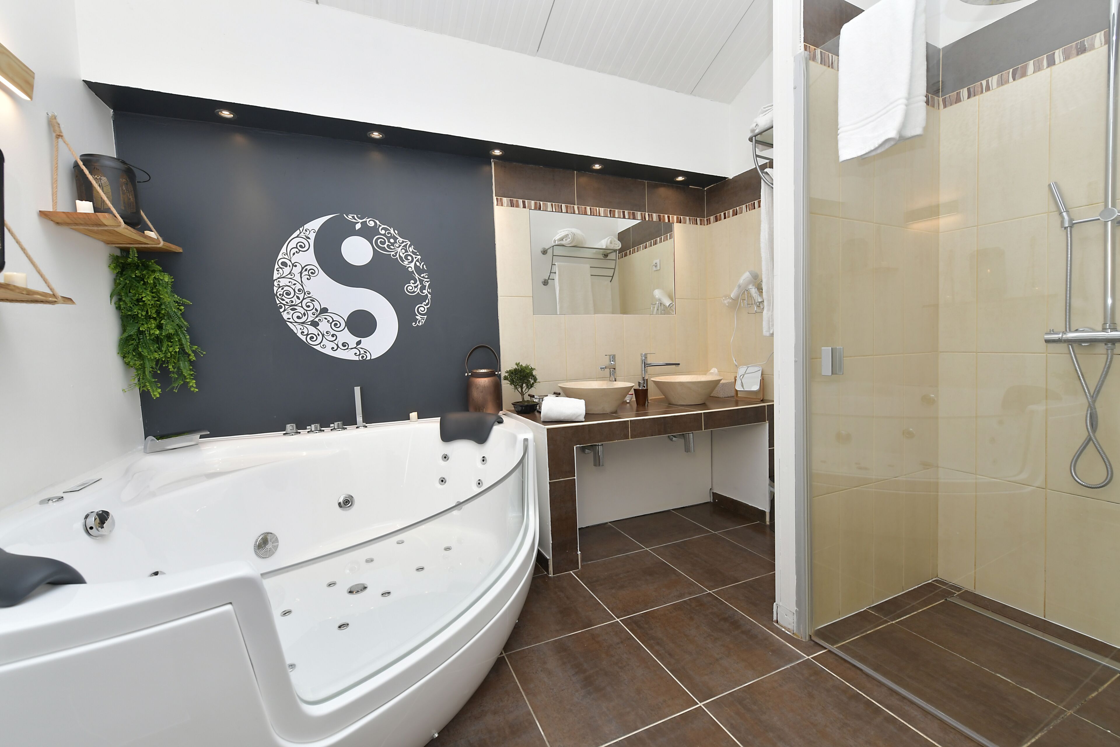 Une salle de bain moderne avec une grande baignoire, un lavabo et un espace douche.