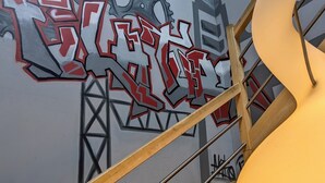 Un escalier avec une rampe et un mur orné de graffitis.