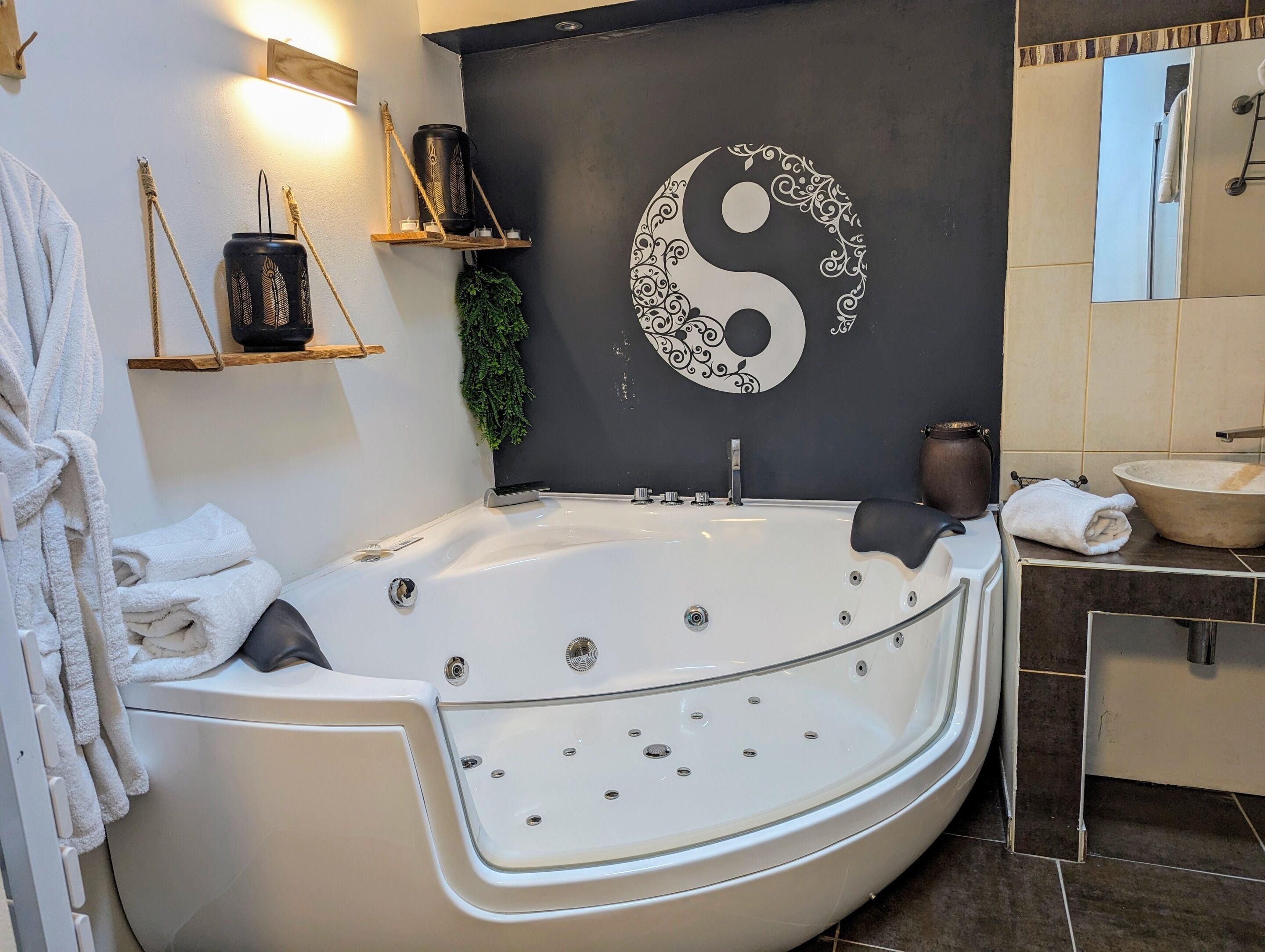 Een moderne badkamer met een groot bad, wanddecoratie in Yin-Yang stijl en een minimalistisch design.