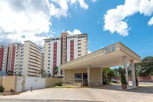 A hotel entrance with a covered area, a gated driveway, and a parking lot.
