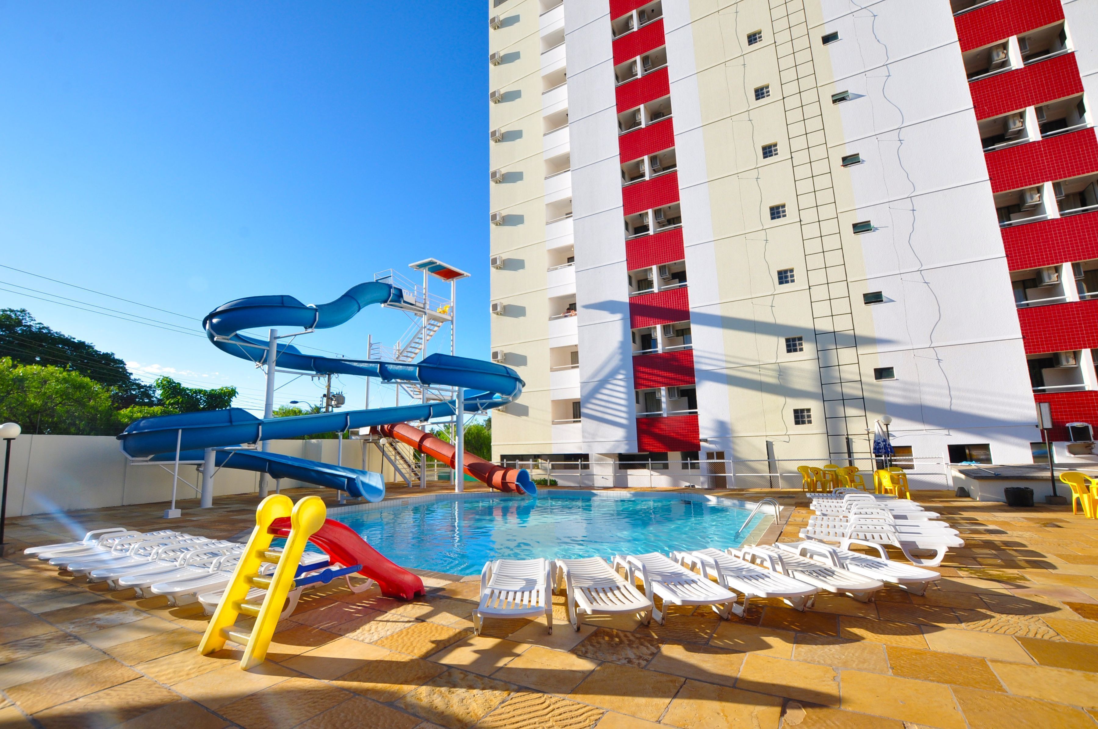 Piscina com toboáguas e espreguiçadeiras.
