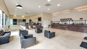A spacious lobby with a reception desk, seating area, and a staircase leading to upper floors. - DiRoma Villas - Direto com o Grupo DiRoma - acesso ao Acqua Park com café da manhã (Caldas Novas)