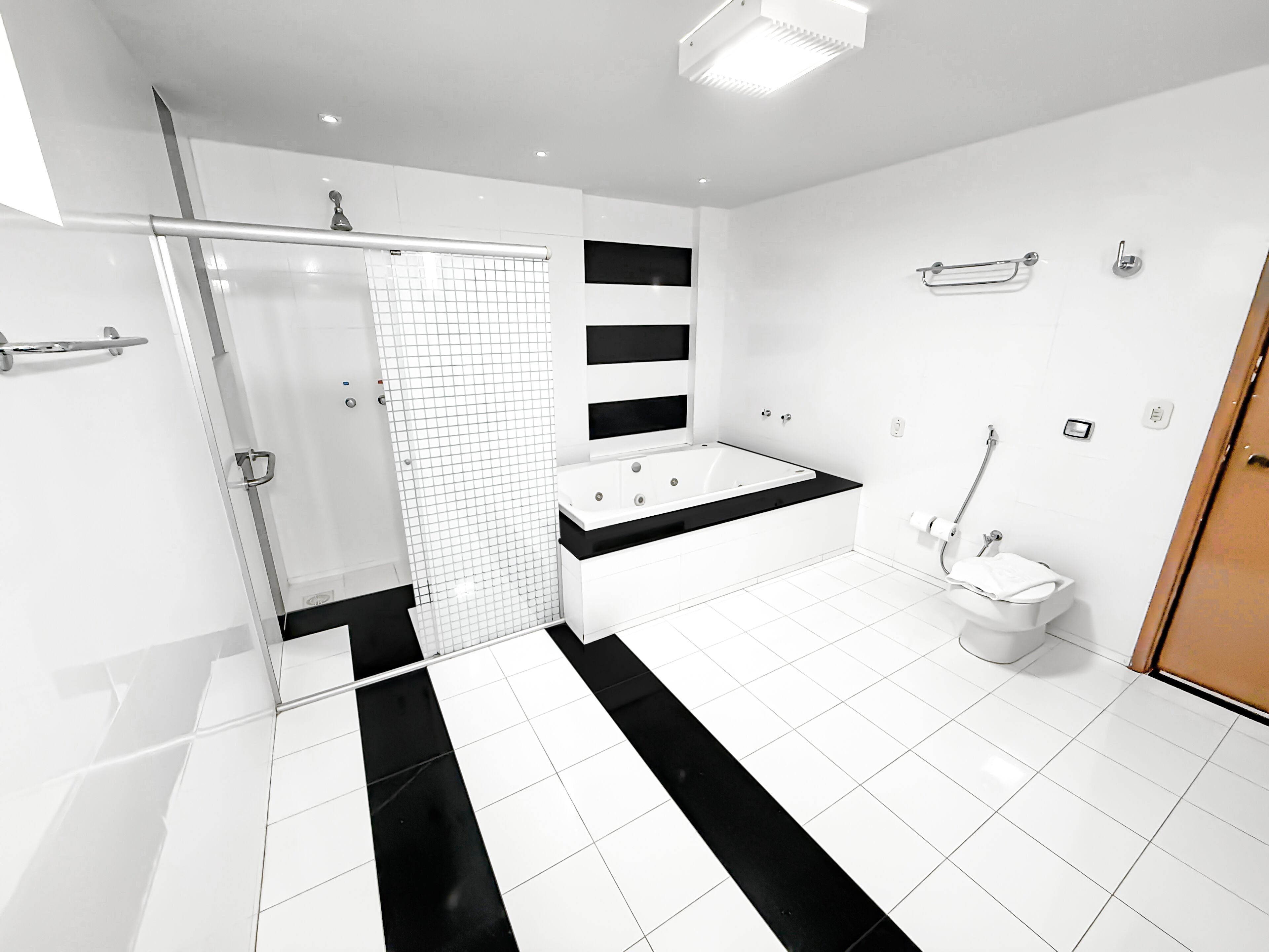 A modern bathroom with a shower, bathtub, and toilet.
