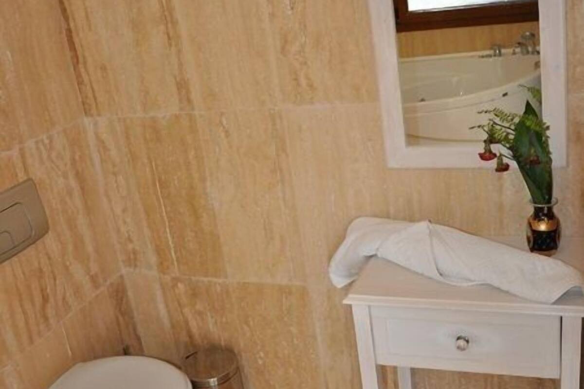 Un baño con inodoro, lavamanos y espejo.