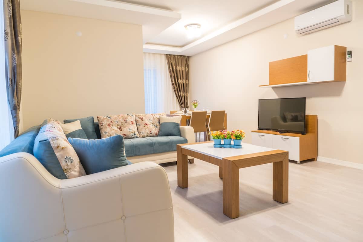 Una sala de estar moderna con un sofá, una mesa de centro, un televisor y un comedor.