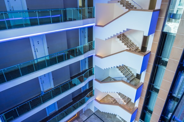 Un intérieur à plusieurs niveaux, doté de rampes et d’escaliers en verre.